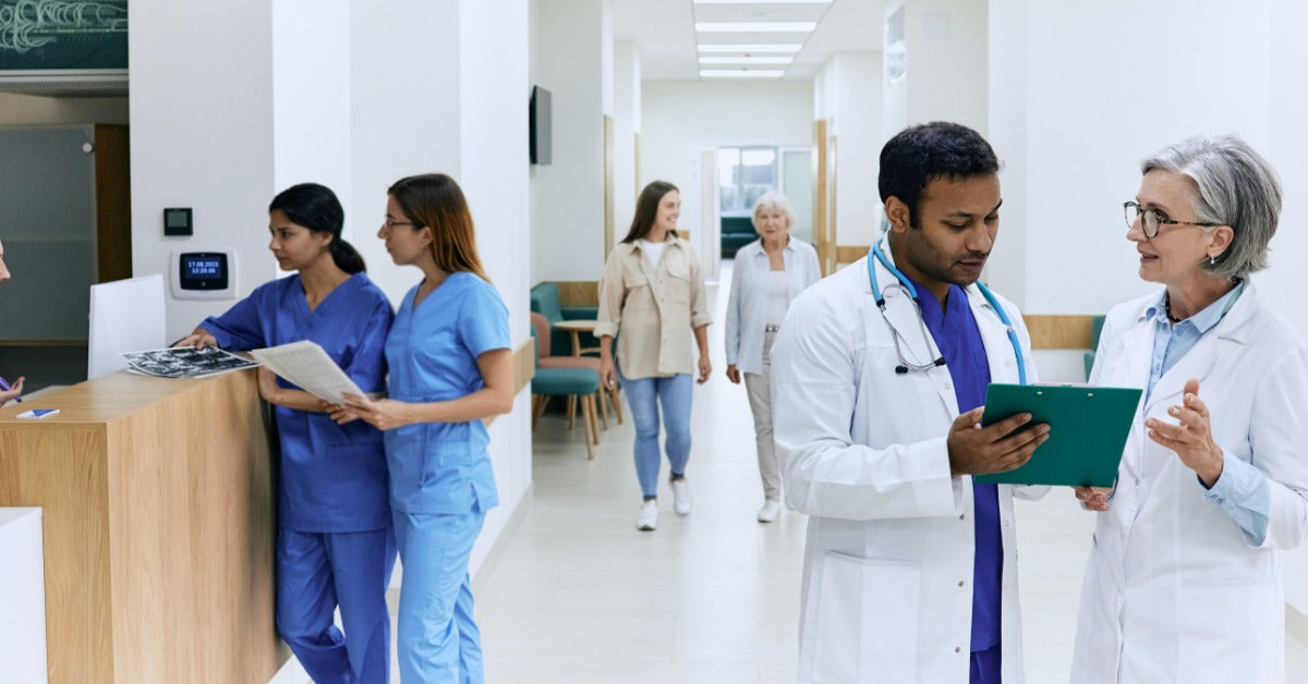 A hospital lobby with several people in it, including doctors, nurses, receptionists, and visitors.